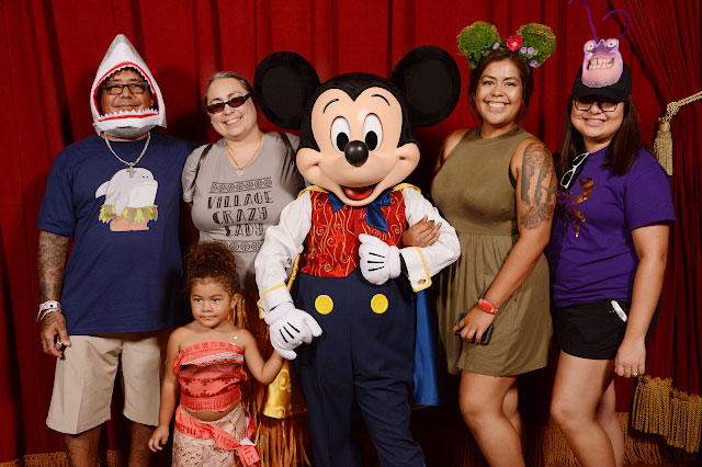 Family dressed in Moana costumes with Mickey Mouse at the Magic Kingdom